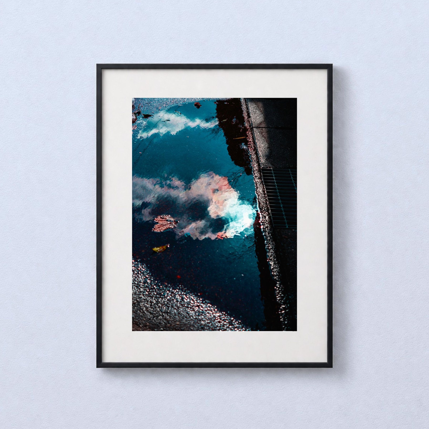 Color in Puddle. shown in a black frame against a grey wall.